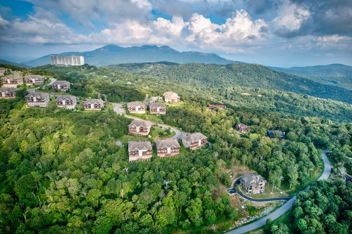 A sweeping view of the surrounding mountain landscape, dotted with homes and traversed by a winding road, provides a sense of the area’s grandeur and adventure. The setting suggests countless opportunities for hiking, exploring, and taking in the natural beauty that draws families to the region.